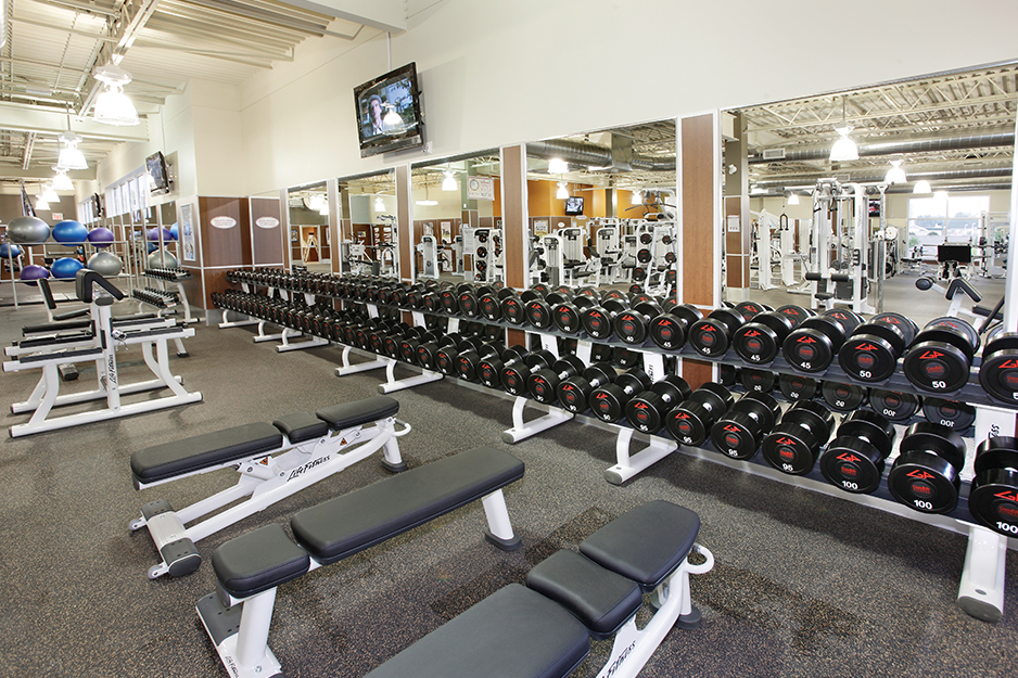 Gym flooring installation in Toronto Ontario. Goodlife gym weight and dumbbell room with rubber flooring, brick walls, and flat screen televisions.