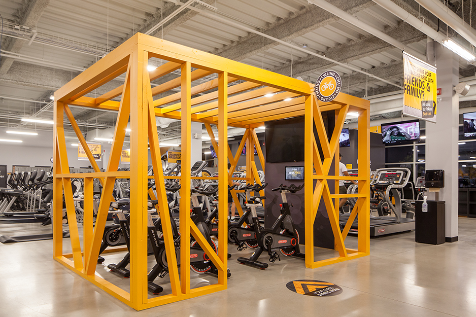 A gym / fitness flooring project in a Markham Ontario, Toronto. A Goodlife gym cycling room with medium-dark hardwood flooring or LVT (luxury vinyl tile).